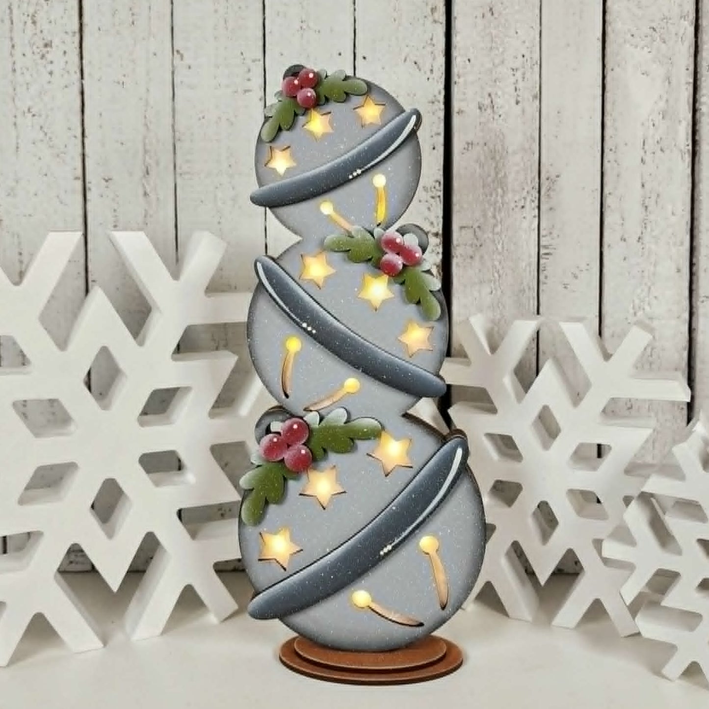 Decorative lamp with spiral design and floral elements on a wooden background