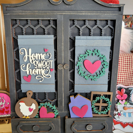 Decorative wall art with heart and wreath designs on a wooden surface.